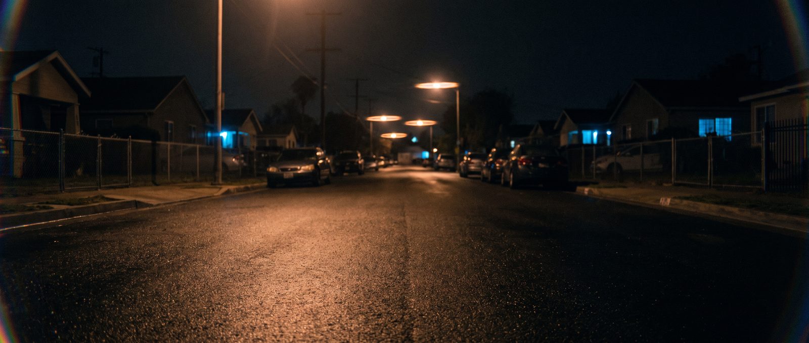 The old street: An empty residential lane at night, three inches above the wet asphalt.